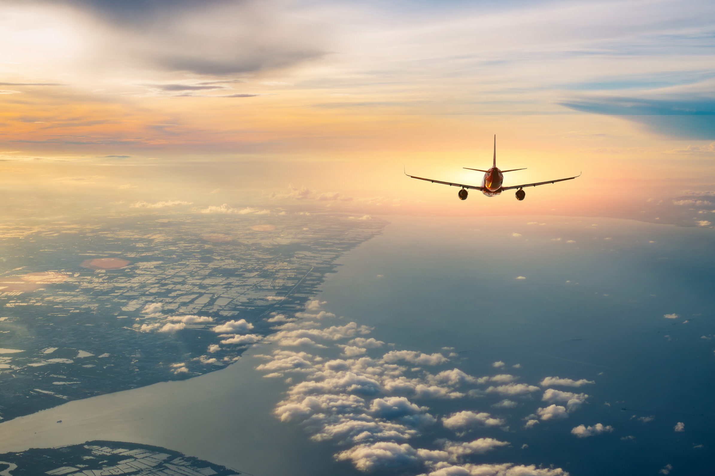 Airplane flying over tropical sea atduring sunset,copy space for text.